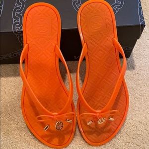 Orange Tory Burch jelly flip flops
